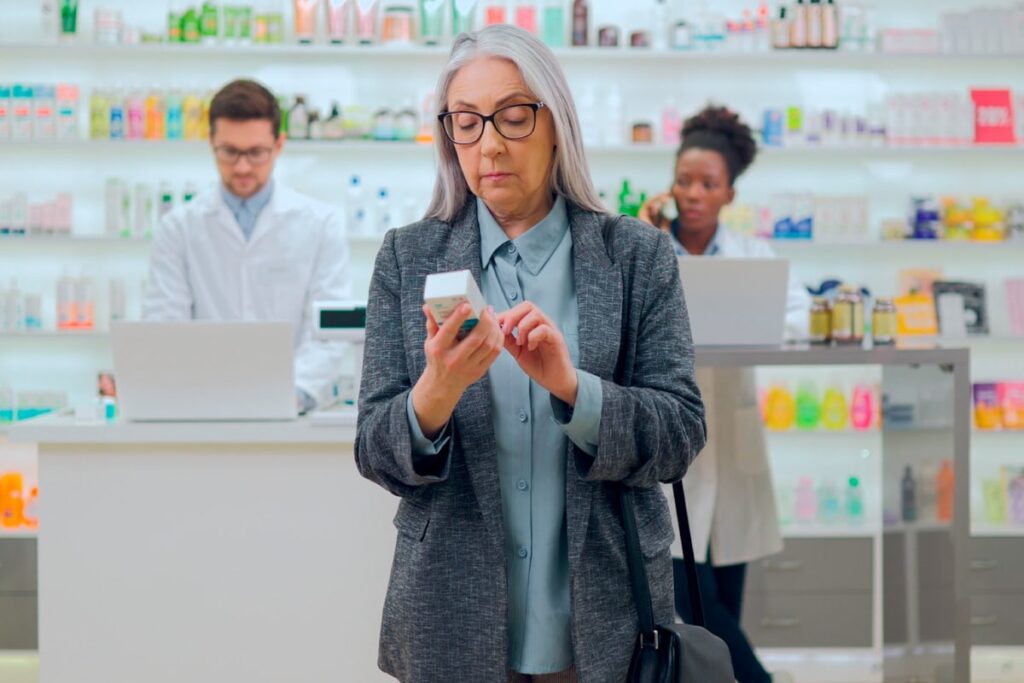 Senior woman checking to see the CBD expiration date on a box before buying.